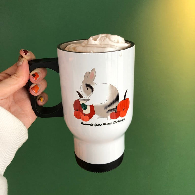 White travel mug with a bunny design holding take away cupe against a green background. Cup is full with vegan whip cream.