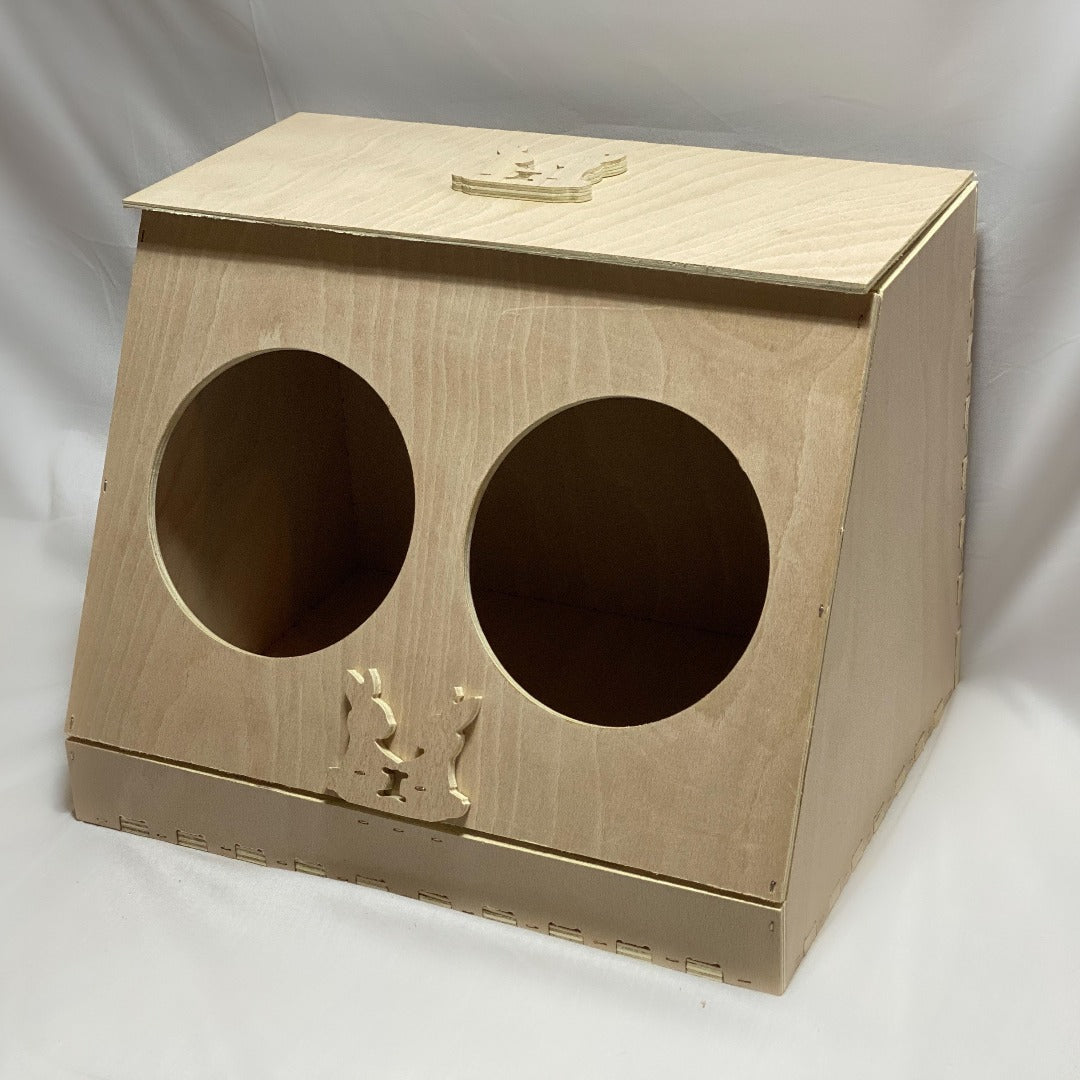 Wooden hay feeder with two holes on front side for rabbits to access hay. Raised logo on top flap and on front middle.
