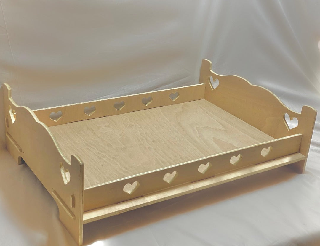 Wooden pet rabbit bed frame with two hearts cut out on the decorative head and foot boards. Five hearts are cut on each side of the bed.