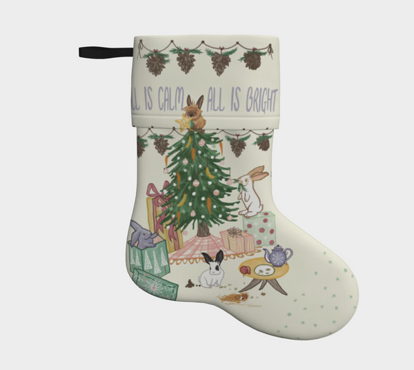 A cream coloured Christmas stocking with a festive, hand drawn design of 4 playful bunnies causing mischief around a Christmas tree, under the phrase 'all is calm, all is bright'.