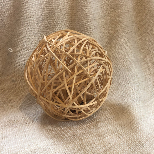 Rosewood rattan wobble ball of woven rattan with water hyacinth ball inside it.