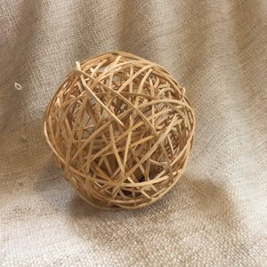 Rosewood rattan wobble ball of woven rattan with water hyacinth ball inside it.