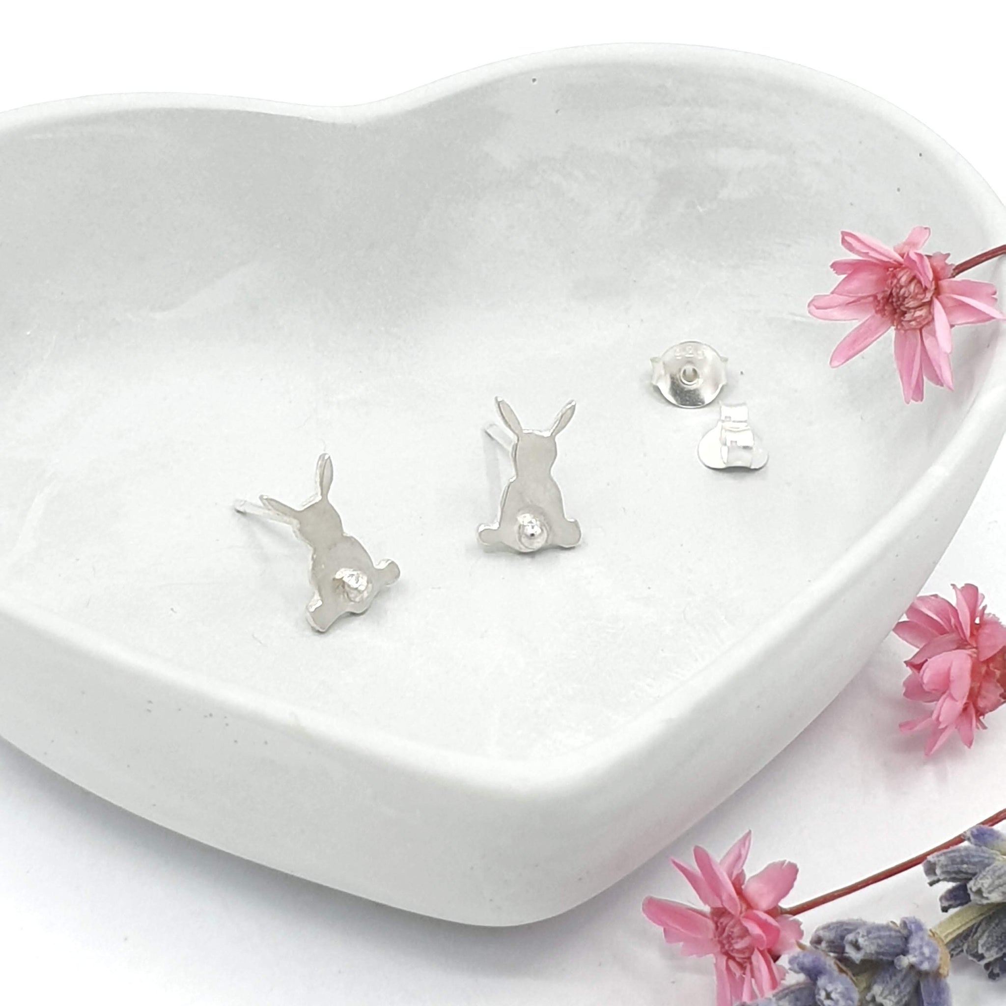 Silver earrings of rabbits from behind with 3D tail detail