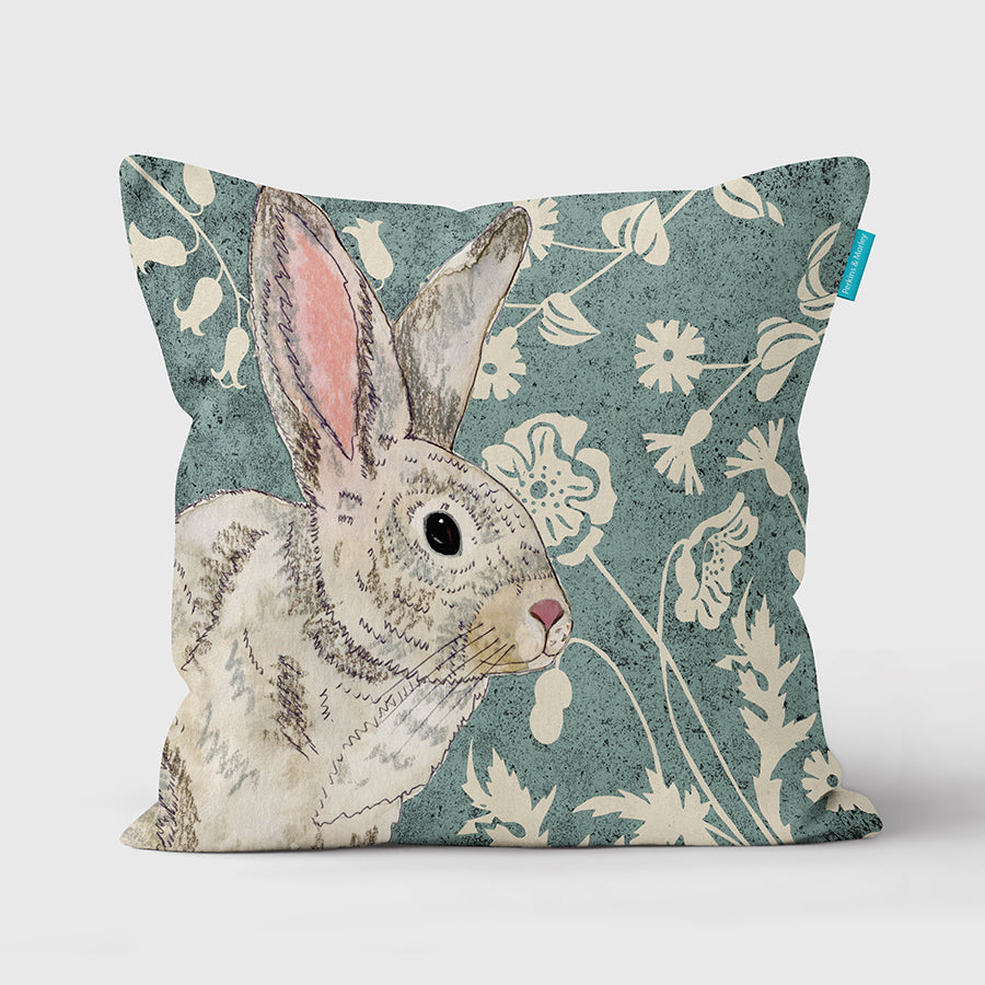 Cushion with a picture of a wildwood rabbit and flowers on it.